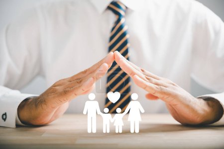 Photo for Supportive family insurance concepts. Businessman protective gesture next to family silhouette. Icons for family, life, health, and house insurance. Highlighting insurance concept. - Royalty Free Image
