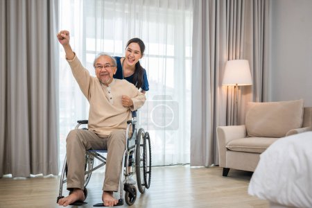 Photo for Happy curator person doctor pushing wheelchair and run elderly disabled patient freedom raising arm at hospital, senior retired man sitting on wheelchair having fun with young woman nurse, health care - Royalty Free Image