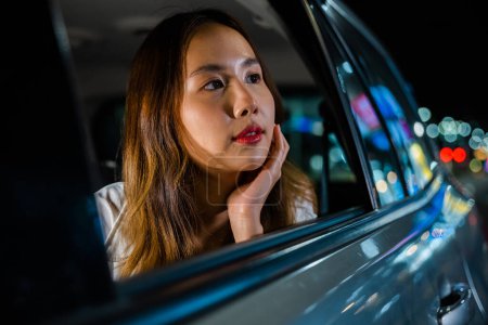 Photo for A woman sits in a car, gazing out the window at the night city streets, lost in contemplation and reflection. The journey is a mix of adventure, solitude, and freedom. - Royalty Free Image