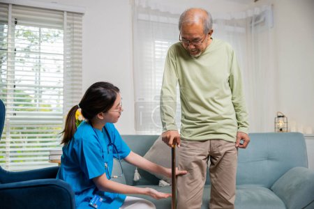 Photo for Asian young woman nurse checking knee and leg after surgery of senior old man patient suffering from pain in knee, doctor asking elderly man about pain symptom with walking stick - Royalty Free Image