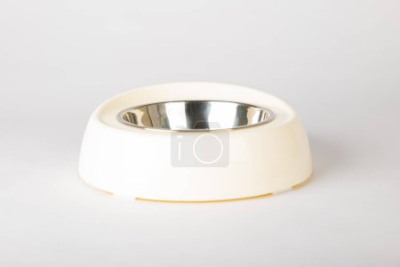 Téléchargez les photos : Un bol isolé pour chat et chien sur un fond blanc propre. Ce plateau circulaire métallique au design épuré est parfait pour servir leurs repas et leur eau, favorisant ainsi les soins aux animaux.. - en image libre de droit