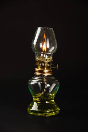 Foto de Una lámpara de aceite antigua, que simboliza la esencia de Diwalis, iluminada sobre un fondo oscuro. Perfecto para transmitir saludos festivos y estética vintage. - Imagen libre de derechos