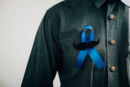 Téléchargez les photos : Mens mains exhibent un ruban bleu avec une moustache, signifiant la solidarité et le soutien pour le cancer du côlon, le cancer colorectal, la sensibilisation à la maltraitance des enfants, Journée mondiale du diabète, et la Journée internationale des hommes. - en image libre de droit
