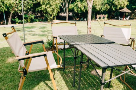 Photo for Experience the joy of outdoor camping with a tent, tables, and chairs for your summer picnic. This suburban patio setup provides comfortable seating and shade, perfect for relaxation. - Royalty Free Image