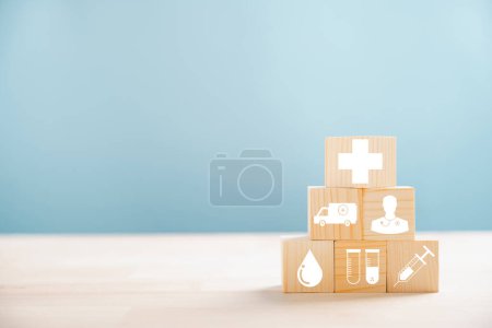 Photo for Pyramid of wooden cubes representing healthcare and insurance ideals. Crowned with a medical insurance icon on white background, offering copyspace for Health Insurance theme. - Royalty Free Image