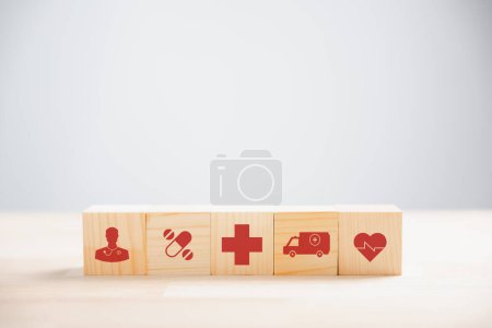Foto de Los bloques de cubo de madera forman una pila piramidal coronada con un icono médico, que ilustra los conceptos de salud y seguros. fondo blanco con espacio de copia para la salud, tecnología médica, ideas de vacunación. - Imagen libre de derechos