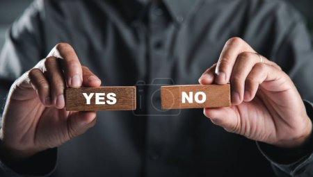 Photo for Hands of businessman holding wooden blocks with yes and no words portraying decision-making. Choice symbolizes business success. Think With Yes Or No Choice. - Royalty Free Image