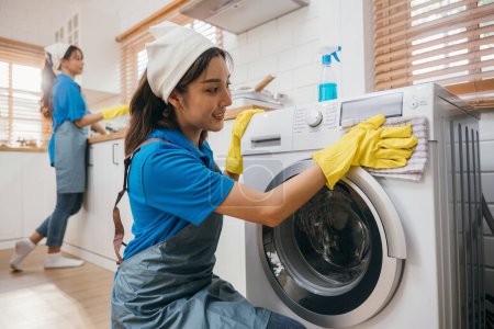 Photo for Woman hand in protective glove cleans and wipes washing machine. Highlighting regular housework and hygiene routine. Cleaner working glove house purity. Clean technology. Maid Cleaning service. - Royalty Free Image