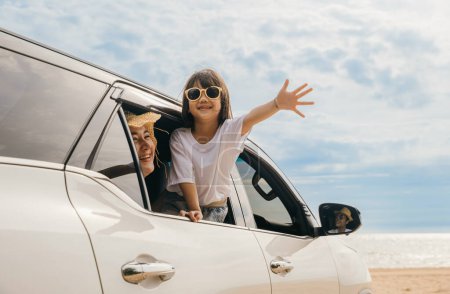 Photo for Happy family day. Asian Dad, mom and daughter little kid smiling sitting in compact car windows raise hand wave goodbye, Summer at beach, Car insurance, Family holiday vacation travel, road trip - Royalty Free Image