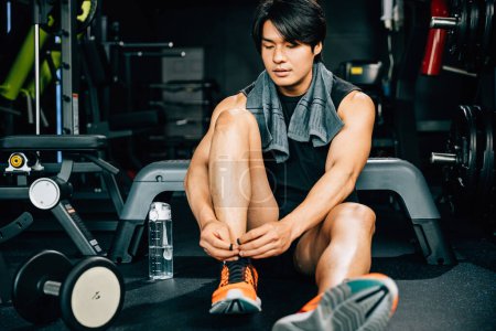 Photo for Sport man athlete is tying his shoelace before a workout, showcasing his sporty shoes and highlighting the importance of proper preparation for exercise. - Royalty Free Image