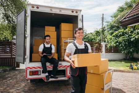 Photo for Moving service workers unload boxes from a van showing teamwork and cooperation. Delivery men in uniform relocating items. Smiling employees carrying orders. relocation teamwork Moving Day - Royalty Free Image