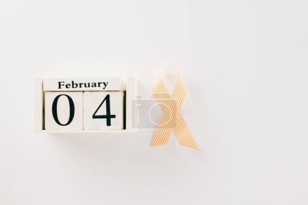 Foto de Pink awareness ribbon sign and Calender 4 February of World Cancer Day campaign isolated on white background with copy space, concept of medical and health care support - Imagen libre de derechos
