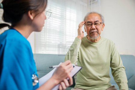 Photo for Asian senior old man patient have headache and woman nurse talking, checking up and recording current symptoms on clipboard in living room, Home healthcare and medical service - Royalty Free Image