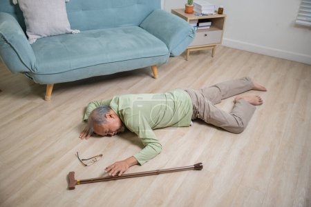 Photo for Older senior man headache lying on the floor after falling down he pain and hurt from osteoporosis, Elderly man falling on the floor alone with walking stick at home, Health care and medicine - Royalty Free Image