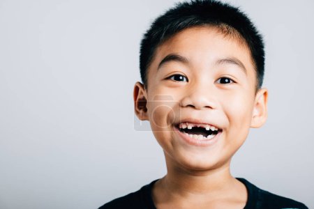 Photo for Smiling schoolboy cheeky grin showing lost milk tooth gap. Child dental care isolated on white. Joyful development tooth change dental hygiene. Children show teeth new gap, dentist problems - Royalty Free Image