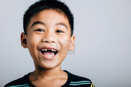 Foto de Muestra a un niño sonriente con un hueco dental superior perdido. Retrato infantil aislado en blanco. Cuidado dental alegre crecimiento diente momento de hadas. Dame que los niños felices muestran los dientes nueva brecha, problemas del dentista - Imagen libre de derechos