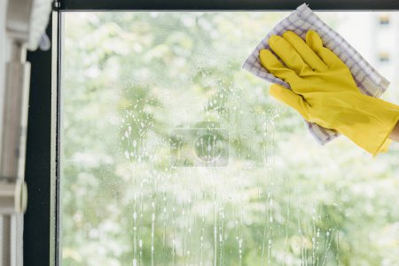 Photo for A cheerful maid sprays and wipes office windows ensuring purity and transparent cleanliness. Her dedication to housework emphasizes hygiene and sparkling windows. - Royalty Free Image