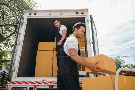 Photo for Workers unload boxes outdoors. Moving service teamwork as delivery men carry boxes. Cooperation in relocation service. Smiling employees working together. relocation cooperation Moving Day - Royalty Free Image