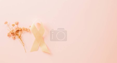 Téléchargez les photos : Pink awareness ribbon sign and paper card flower of World Cancer Day on pink background with copy space, concept of medical and health care support, Breast cancer awareness concept, 4 February - en image libre de droit