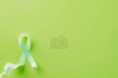 Foto de Green awareness ribbon symbol of Gallbladder and Bile Duct Cancer month isolated on green background with copy space, concept of medical and health care support, Cancer awareness, World bipolar day - Imagen libre de derechos