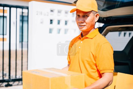 Photo for A smiling man a logistic worker in uniform delivering cardboard boxes to a recipient at home. Illustrating efficient delivery service with a confident portrait of the worker. - Royalty Free Image