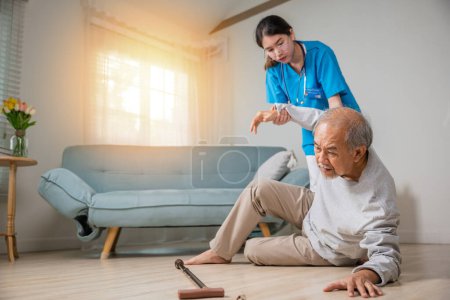 Téléchargez les photos : Asiatique aîné homme âgé tombant sur le sol couché et infirmière femme est venu pour aider à soutenir, handicapé vieillard patient tomber et soignant jeune assistant à la maison de soins infirmiers - en image libre de droit