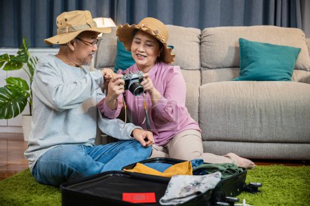 Photo for Travel and tourism. Asian couple old senior marry retired couple smiling taking photo by camera during luggage suitcase arranging for travel, Happy mature retired couple photography weekend holiday - Royalty Free Image