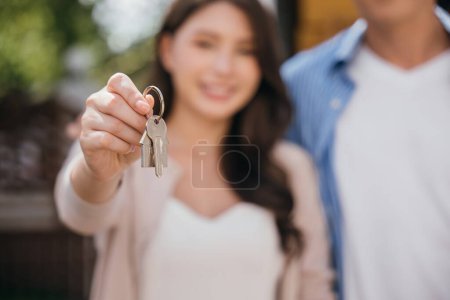 Téléchargez les photos : Couple célèbre déménagement réussi de la maison mettant en valeur les clés et portant un matelas. Leur bonheur symbolise la joie de se déplacer dans l'immobilier. Concept de déménagement - en image libre de droit
