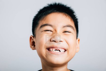Téléchargez les photos : Enfant sourit dent supérieure a perdu l'écart évident. Croissance dentaire isolée sur blanc. Joyeux moment de fée dentaire. Les enfants montrent des dents nouveau fossé, problèmes de dentiste. petit garçon pas de dent - en image libre de droit