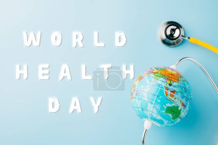 Photo for World Health Day Concept. Top view yellow doctor stethoscope and world globe isolated on pastel blue background with copy space, Save world day, Environment Green Earth, Health care and medical - Royalty Free Image