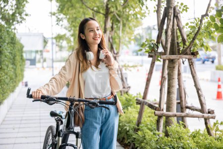 Foto de Mujer feliz sonriente caminar por la calle con su bicicleta en la carretera de la ciudad, el medio ambiente ECO, Estilo de vida Mujer joven asiática caminando junto con la bicicleta en verano en el campo al aire libre, viajes saludables - Imagen libre de derechos