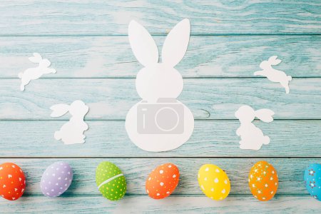 Photo for Easter Day Concept. Top view holiday banner background web design white colorful easter eggs and paper bunny rabbit on blue wood background with copy space, celebration greeting, overhead, template - Royalty Free Image