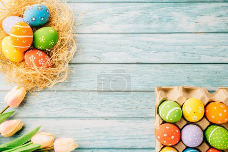 Foto de Happy Easter Day Concept. Flat lay of holiday banner background web design easter eggs in brown nest on blue wooden background with empty copy space, celebration greeting card, overhead, template - Imagen libre de derechos