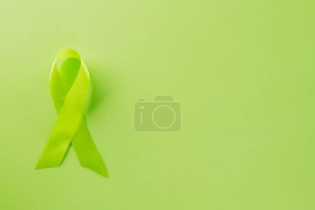 Photo for Green awareness ribbon of Gallbladder and Bile Duct Cancer month isolated on green background with copy space, concept of medical and health care support, Cancer awareness, World kidney day - Royalty Free Image