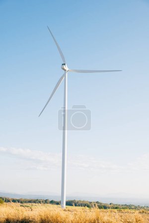 Téléchargez les photos : Au milieu de la beauté de la nature, un parc éolien sur une montagne symbolise l'innovation moderne dans l'énergie propre. Turbines tournent gracieusement soutenir le développement durable contre le ciel bleu serein. - en image libre de droit