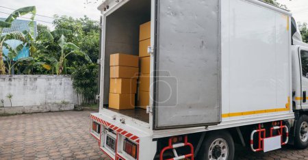 Photo for Outdoor scene, White delivery van and open car trunk carrying cardboard boxes. Logistic service for transporting items. House relocation. Moving Day Concept. - Royalty Free Image