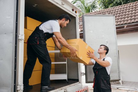 Photo for Teamwork in action, workers unload boxes from the moving truck for customer relocation. The company dedication ensures a smooth move and happiness. Moving Day - Royalty Free Image