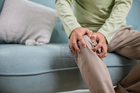 Photo for Old age. Asian senior man retirement knee joint pain on sofa, Elderly old man sitting down hands hold knee, Grandfather people health care bone problem at home - Royalty Free Image