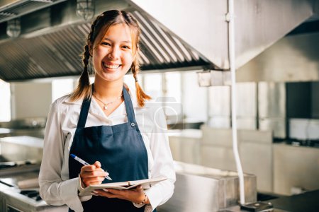 Photo for Professional chefs portrait in commercial kitchen. Holding note book pen for teaching. Expertise in education explaining skills. Working confidently presenting ideas to colleagues. Foor education - Royalty Free Image