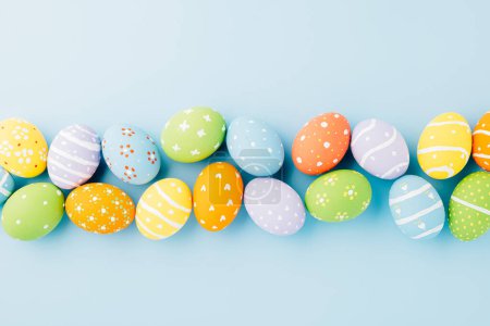 Photo for Overhead easter eggs isolated on blue background with copy space, Funny decoration, Happy Easter Day greeting card, Creative composition banner web design holiday background, flat lay top view - Royalty Free Image