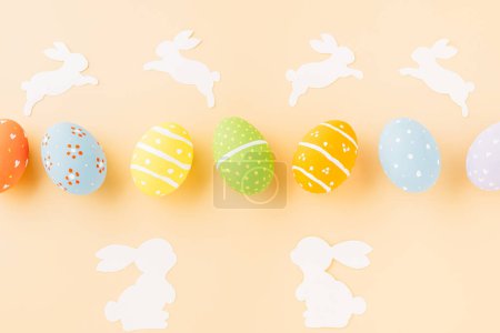 Téléchargez les photos : Easter eggs bunny and rabbit white paper cut isolated on pastel background copy space, Funny decoration, Creative composition banner web design holiday background, Happy Easter Day, flat lay top view - en image libre de droit