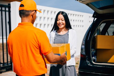Photo for Efficient delivery logistics illustrated with a courier handing a cardboard parcel to a smiling woman customer at her home. Emphasizing modern home delivery service and customer happiness. - Royalty Free Image
