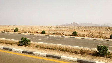 Foto de Camino en el desierto del Sinaí, Sharm el Sheikh carretera a través de la ciudad y el desierto. Paisaje urbano en Egipto - Imagen libre de derechos