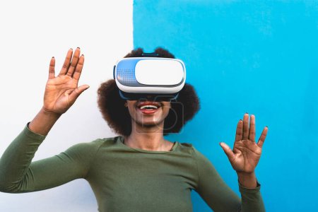 Foto de Joven mujer africana divirtiéndose con gafas futuristas de realidad virtual - Concepto metaverso - Imagen libre de derechos
