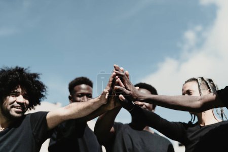 Téléchargez les photos : Heureux groupe de personnes africaines s'amuser à empiler les mains ensemble en plein air - en image libre de droit