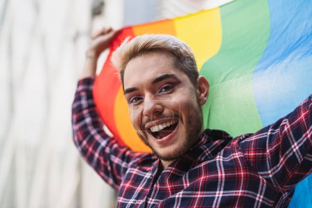 Photo for Happy gay man celebrating the pride festival with the LGBTQ rainbow flag - Royalty Free Image