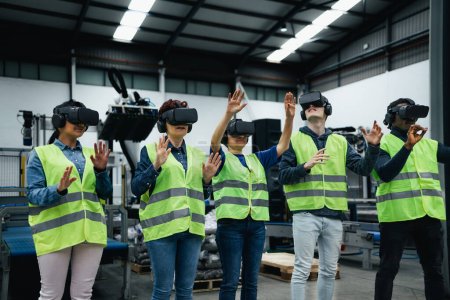 Foto de Equipo de ingenieros con experiencia en simulación con gafas de realidad virtual futuristas dentro de fábrica robótica - Industria tecnológica y concepto metaverso - Imagen libre de derechos