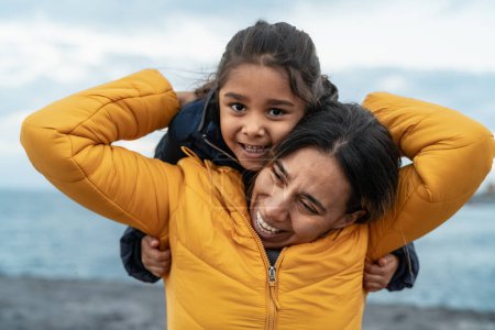 Téléchargez les photos : Bonne mère latine profiter du temps avec son enfant pendant les vacances d'hiver - concept de famille et d'amour - en image libre de droit