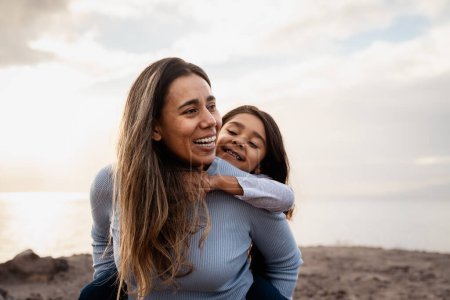 Téléchargez les photos : Happy Latin mother enjoying time with her child on the beach - Family and love concept - en image libre de droit