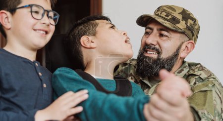 Foto de Military soldier having tender moment together his son with disability at home - Family love concept - Imagen libre de derechos